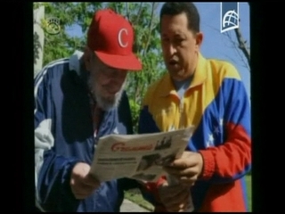 Fidel Castro y Chávez con vestimentas deportivas, de pie en un jardín conversando