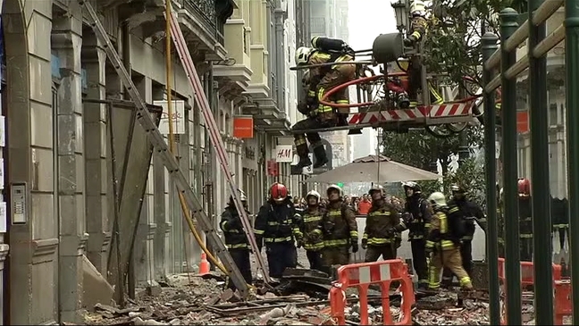 Evacúan a uno de los bomberos tras el derrumbe del edificio incendiado