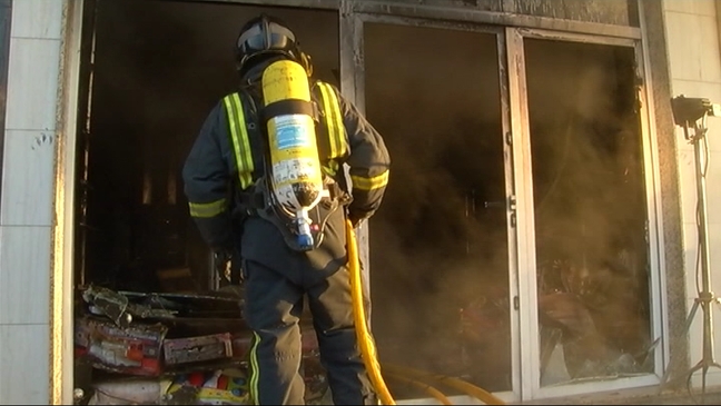 Bombero trabajando en el incendio del bazar de Sotrondio