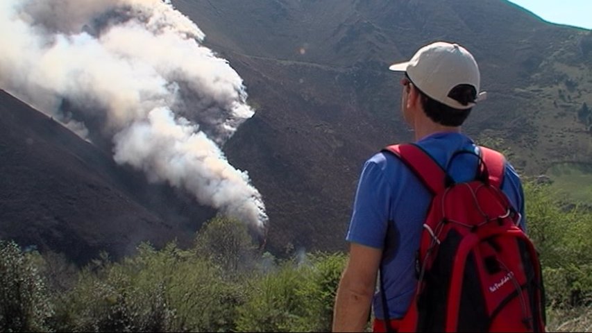 Un turista observa el fuego en Onís