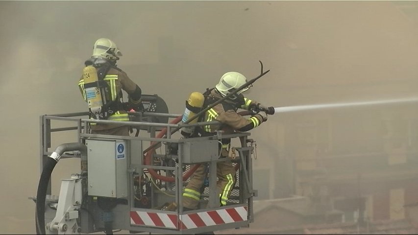 Los Bomberos de Oviedo trabajando en el incendio de Uría desde un brazo articulado