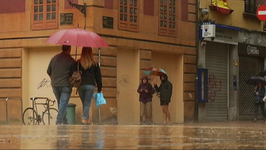 Dos parejas se protegen de la lluvia