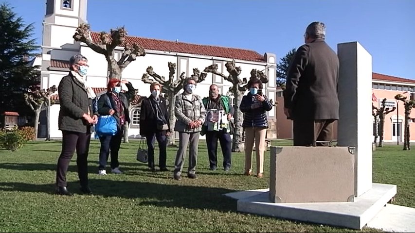 Visitantes admiran la placa conmemorativa de Somao, Pueblo Ejemplar 2020