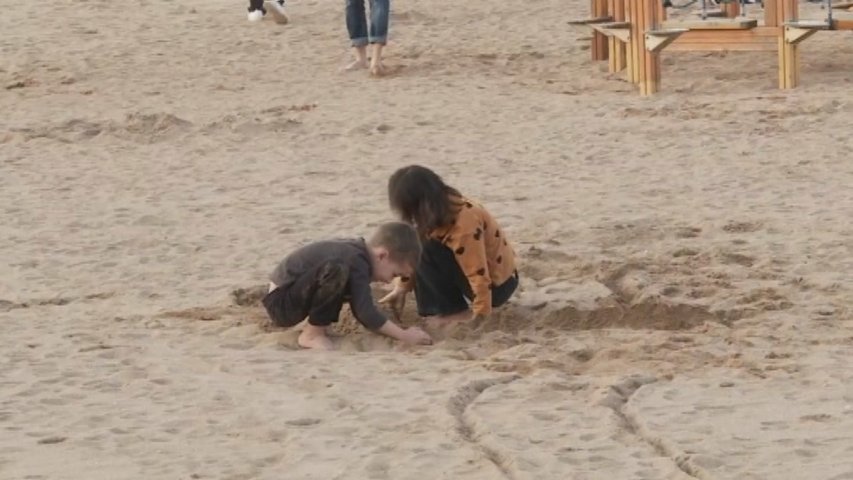 Dos niños juegan en la playa en pleno diciembre