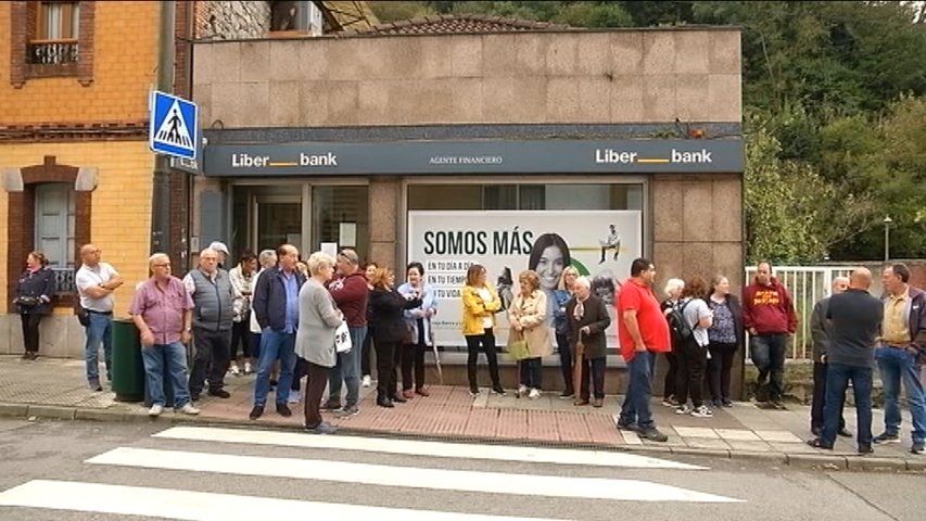 Vecinos de Olloniego concentrados frente a la sucursal de Liberbank que acaban de cerrar