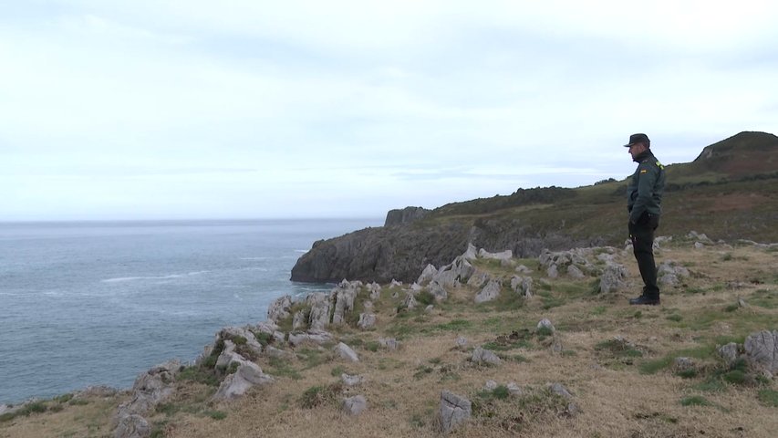 Un miembro del operativo vigila desde tierra el operativo de búsqueda marítima de un hombre en Llanes