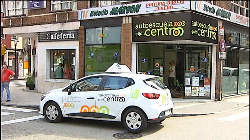 Un coche de una autoescuela en una calle gijonesa