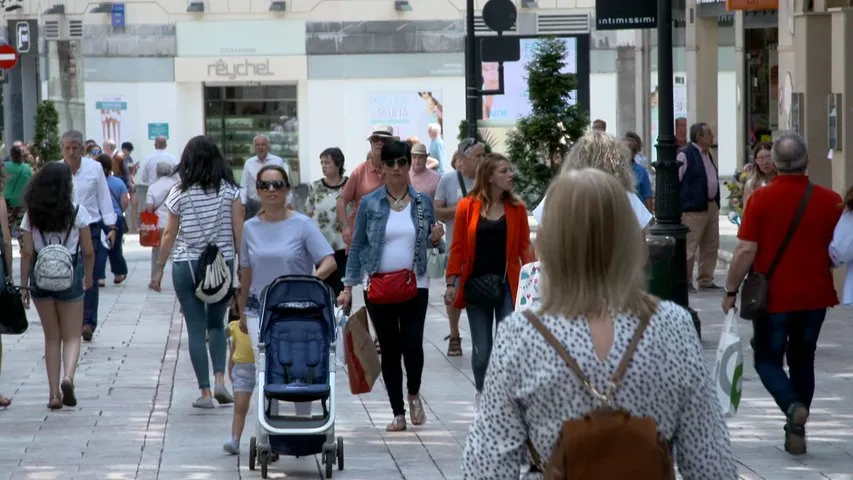 Gente paseando por la calle por un barrio gijonés