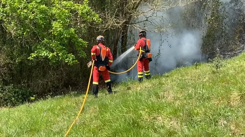 Dos bomberos apagando un incendio en Asturias